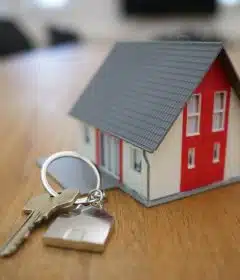 white and red wooden house miniature on brown table