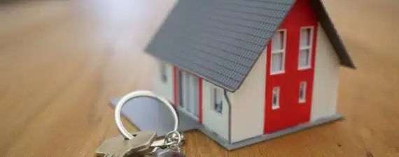 white and red wooden house miniature on brown table